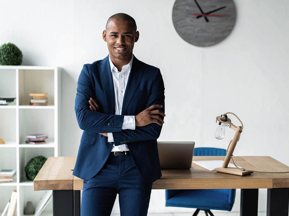 A professional man standing in his office smiling