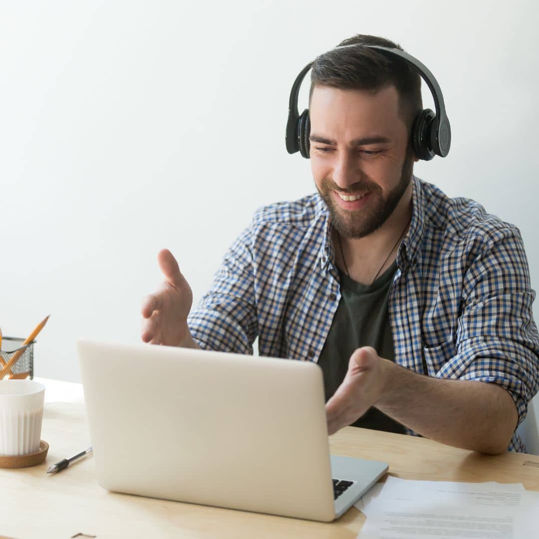 person wearing headset working on laptop