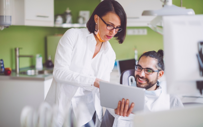 Dentist showing patient a tablet