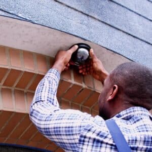 man installing security camera