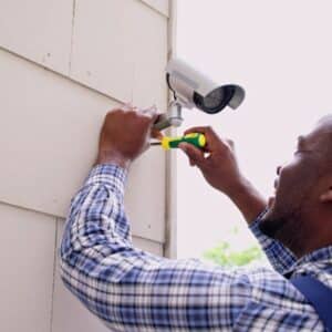 man installing security camera
