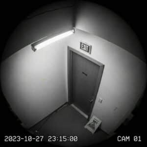 grainy, low-resolution security camera view of a doorway