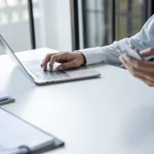 Person using a laptop and their phone